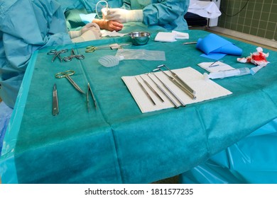 a plastic surgeon performs hand surgery on a patient in an operating room