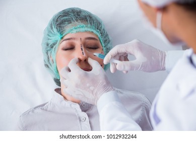 Plastic surgeon preparing for operation on woman face