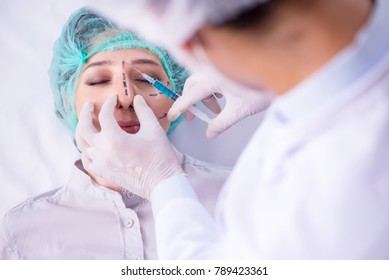 Plastic surgeon preparing for operation on woman face