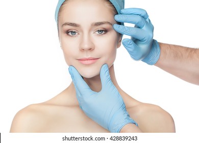 Plastic Surgery Concept. Doctor Hands In Gloves Touching Woman Face