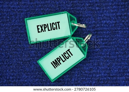Plastic tag with the words explicit and implicit. Explicit – clearly stated so there is no room for confusion or questions. Implicit – implied or suggested, but not clearly stated.