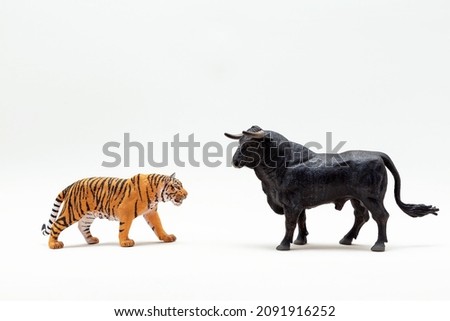 Plastic tiger and bull figurines close-up. The year of the bull is leaving , the year of the tiger is coming. The symbol of 2022 is a tiger
