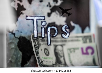 A Plastic Tip Jar With Five Dollar Bill In It. On The Background Of A Black Airplane Silhouette And World Map.