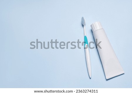 Plastic toothbrush and paste on light background, flat lay. Space for text