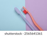 Plastic toothbrushes on pastel background. Top view