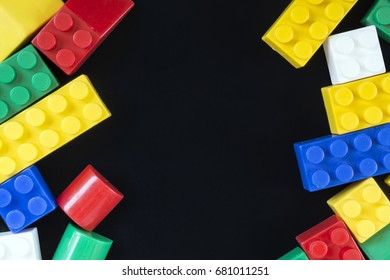 Plastic Toy Bricks On Black Background. Copy Space