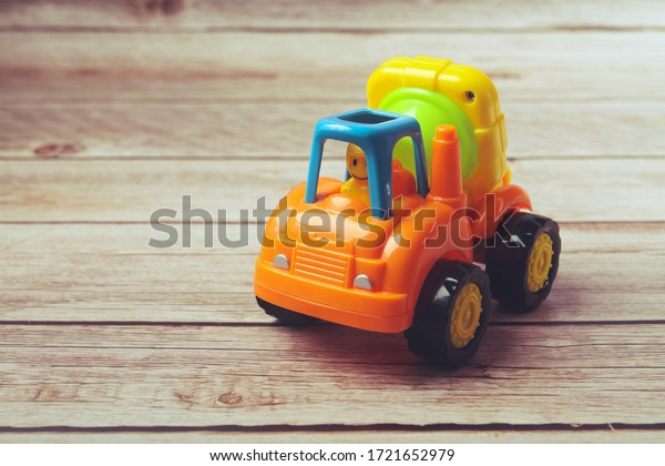 Plastic toy cement mixer truck for kids\
isolated on wooden\
table	\
