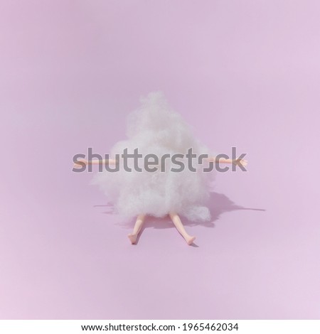 Plastic toy doll covered with wool on purple background. Minimal composition.