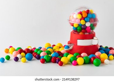 A plastic toy gum ball machine with colourful gum balls all around.