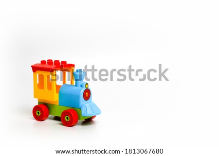 plastic toy multicolored steam locomotive for childrens games on a white background, place for text
