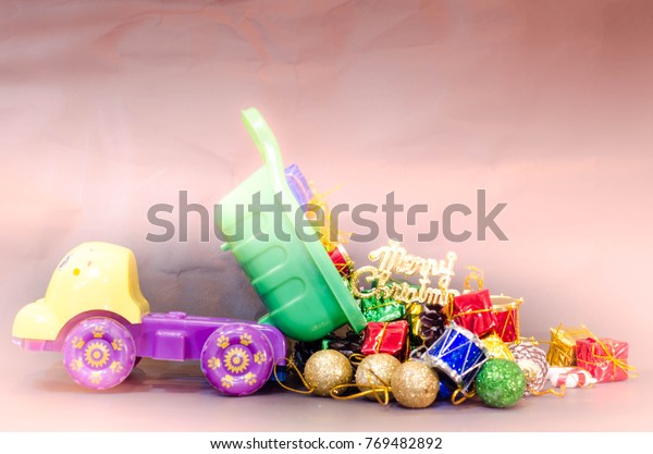 plastic toy truck load stuff and\
present gift boxes dump its tray on ground with light\
background