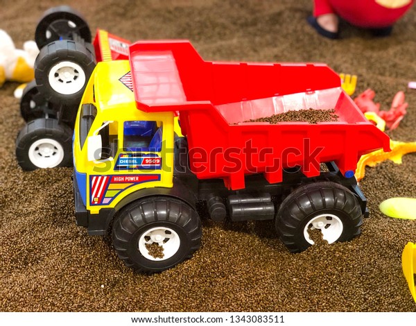 Plastic toy truck in the sand\
box