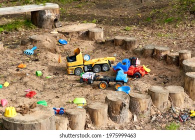 Plastic toys in the sandbox on the playground in the park. Toys abandoned and forgotten in the sandbox