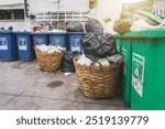 Plastic trash cans and baskets. A full garbage bin and overflowing. Waste collection points in the community including condo apartments in the area at Bangkok of Thailand.