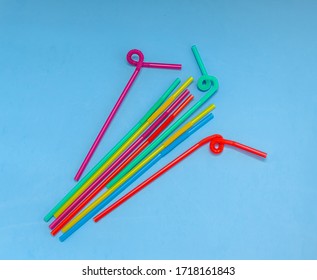 Plastic tubules for drinks on a blue background. Children's party with cocktails. The concept of environmental pollution by plastic, ecology.