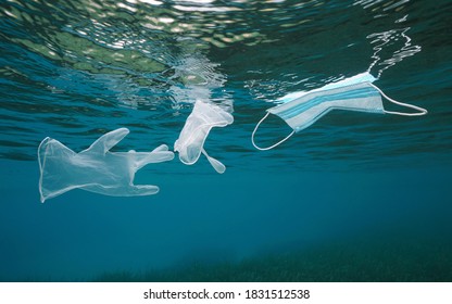 Plastic waste pollution in the sea since coronavirus COVID-19 pandemic, gloves with a face mask floating under water surface
