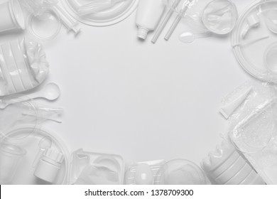 Plastic waste. Single-use plastic objects, ecological pollution. Frame poster background of white packaging plastic products. Top view flat lay.