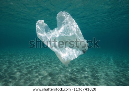 Plastic waste underwater, a plastic bag in the Mediterranean sea between water surface and a sandy seabed, Almeria, Andalusia, Spain