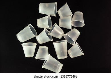 Plastic Waste - White Plastic Yogurt Cups With Recycling Code PS 06 Polystyrene, Isolated, Black Background