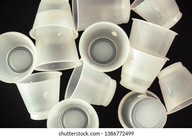 Plastic Waste - White Plastic Yogurt Cups With Recycling Code PS 06 Polystyrene, Isolated, Black Background