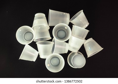 Plastic Waste - White Plastic Yogurt Cups With Recycling Code PS 06 Polystyrene, Isolated, Black Background