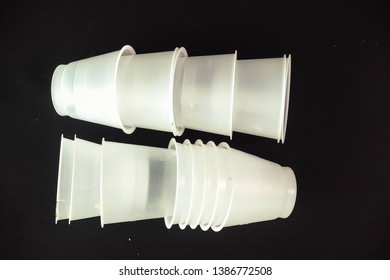 Plastic Waste - White Plastic Yogurt Cups With Recycling Code PS 06 Polystyrene, Isolated, Black Background