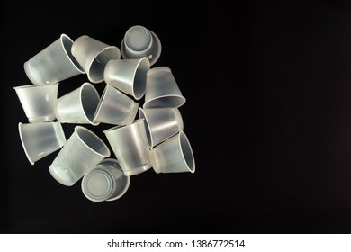 Plastic Waste - White Plastic Yogurt Cups With Recycling Code PS 06 Polystyrene, Isolated, Black Background