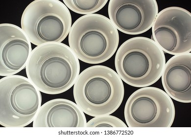 Plastic Waste - White Plastic Yogurt Cups With Recycling Code PS 06 Polystyrene, Isolated, Black Background