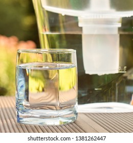 Plastic Water Filtration Pitcher And A Clean Glass Of A Clear Water On The Summer Garden Background In Sunny Warm Summer Day In Countryside