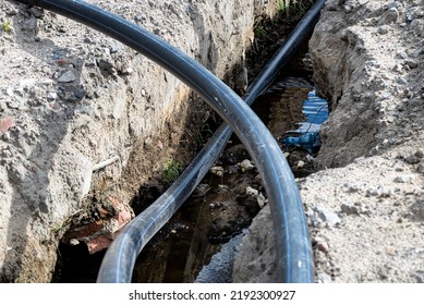 Plastic Water Pipe Lying In A Ditch With High Groundwater, Water Connection On The Estate.