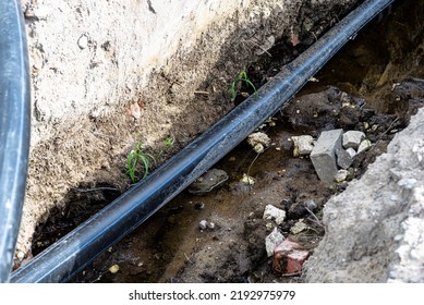 Plastic Water Pipe Lying In A Ditch With High Groundwater, Water Connection On The Estate.