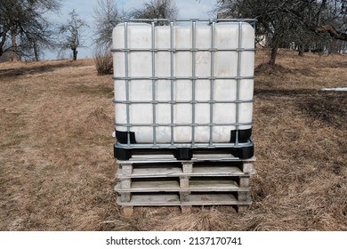 Plastic water tank. Water tank in the form of a container. Water tank on the street. Plastic barrel with a metal frame