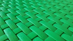 Plastic Weave Pattern Background. Zigzag Interlocking Of Symmetrical Shapes. Green Woven Background.