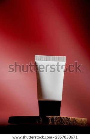 Plastic white tube for cream or lotion. Skin care or sunscreen cosmetic on red background.