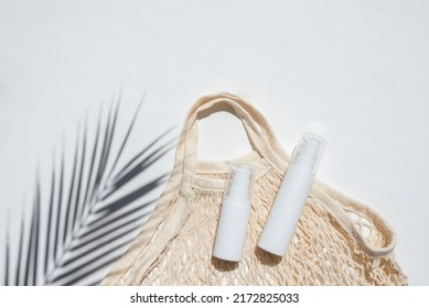 Plastic White Tubes For Cream Or Lotion And Cloth Shopping Bag. Sunscreen Cosmetic On White Background With Shadows From Palm Leaves. Beauty Summer Concept For Face Care