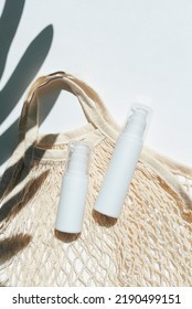 Plastic White Tubes For Cream Or Lotion And Cloth Shopping Bag. Sunscreen Cosmetic On White Background With Shadows From Palm Leaves. Beauty Summer Concept For Face Care