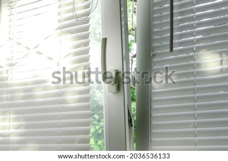 A plastic window with blinds is open for ventilation mode.
