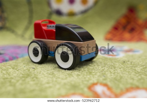 Plastic and\
wood toy car on a colorful\
background