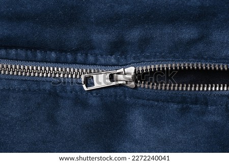 Plastic zipper background. Dark coat zipper. Empty copy space fabric texture. Closeup zipper teeth. Metal shiny clothing part. Closeup zipped zipper.
