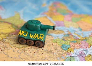 A Plasticine Tank On The Background Of A World Map, As A Symbol Of Peace And Goodness. There Is No War Appeal. Stop War.