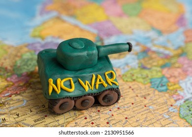 A Plasticine Tank On The Background Of A World Map, As A Symbol Of Peace And Goodness. There Is No War Appeal. Stop War.