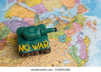 A Plasticine Tank On The Background Of A World Map, As A Symbol Of Peace And Goodness. There Is No War Appeal. Stop War.