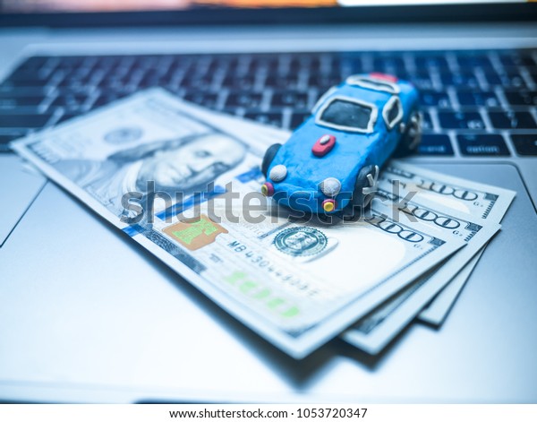 Plasticine toy car with dollars is on the
laptop. The
programmer