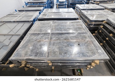 Plastic-wrapped window frames stacked in warehouse, ready for delivery