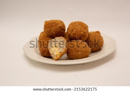Plate of 7 Savoury Eggs on plate isolated on white background. Pork sausagemeat and chopped boiled egg fried in crispy breadcrumbs
