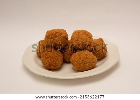 Plate of 7 Savoury Eggs on plate isolated on white background. Pork sausagemeat and chopped boiled egg fried in crispy breadcrumbs