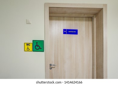 Plate Is Acrylic. Door Sign, Doorplate Hangs On Light Gray Wooden. Number. Interior Of School, Kindergarten, Institute, Public. Inscription WC, Disabled, Bathroom MGN (people With Limited Mobility) 