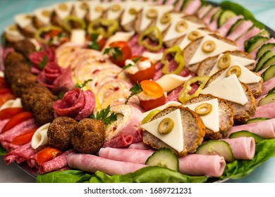 Plate of arranged, delicious cold cuts with mozzarella, tomato, olive, rolled ham, salami and cheese. Selective focus