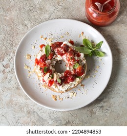 plate with bagel with cream cheese, strawberry jam and basil on the table - Powered by Shutterstock