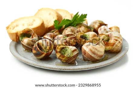 plate of baked escargot snails filled with parsley and garlic butter isolated on white background